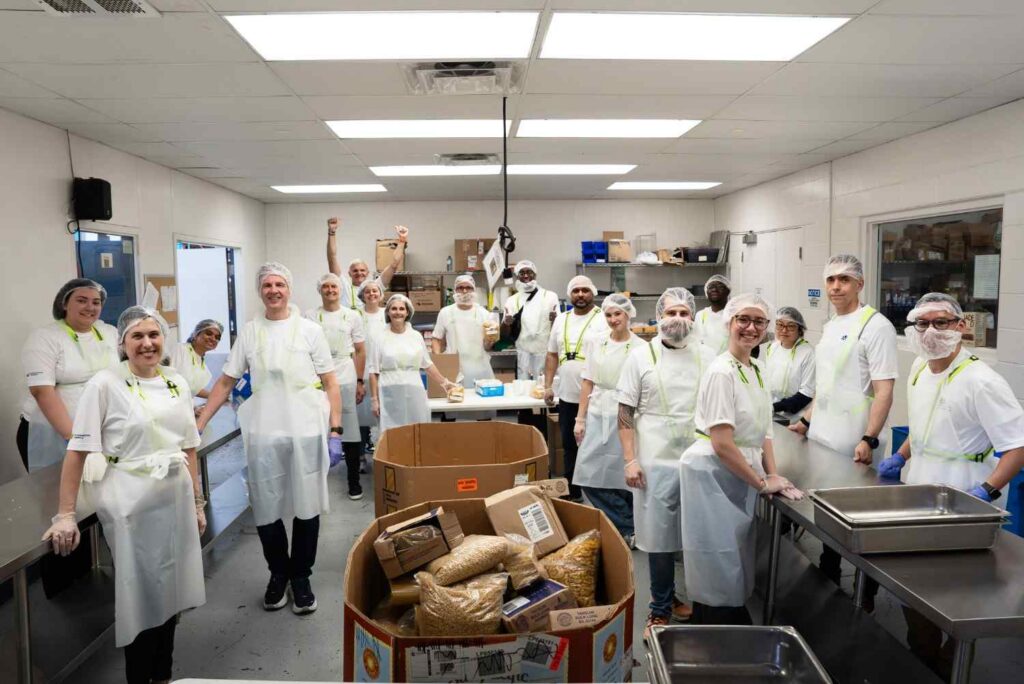 Canada Building Materials' Community Involvement - volunteers in hairnets sorting food donations in a food bank kitchen