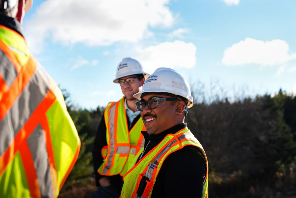 CBM employees wearing hard hats, safety glasses, and high-visibility vests.